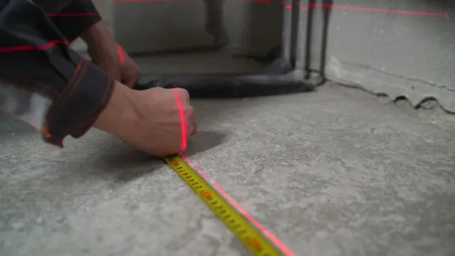 man meet betonnen vloer