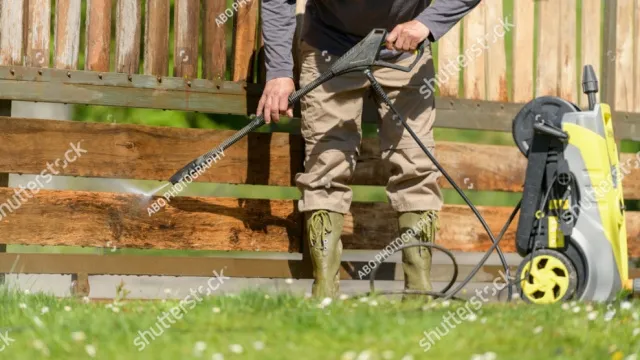 man reinigt tuinschutting met hogedrukreiniger