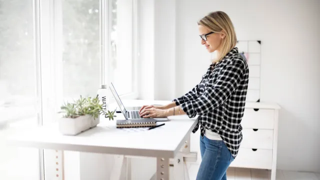 vrouw werkt staand aan bureau