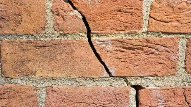schuine scheur in bakstenen muur