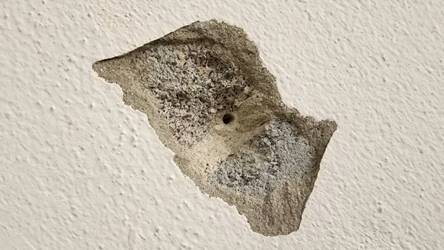 boorgat in beschadigd pleisterwerk