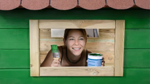 woman paints garden house