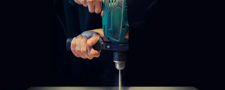 man werkt met boormachine