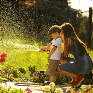 mother and child spraying lawn