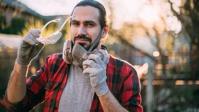 man with safety glasses, gloves, and a dust mask