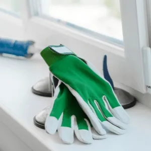 kitspuit en werkhandschoenen in vensterbank